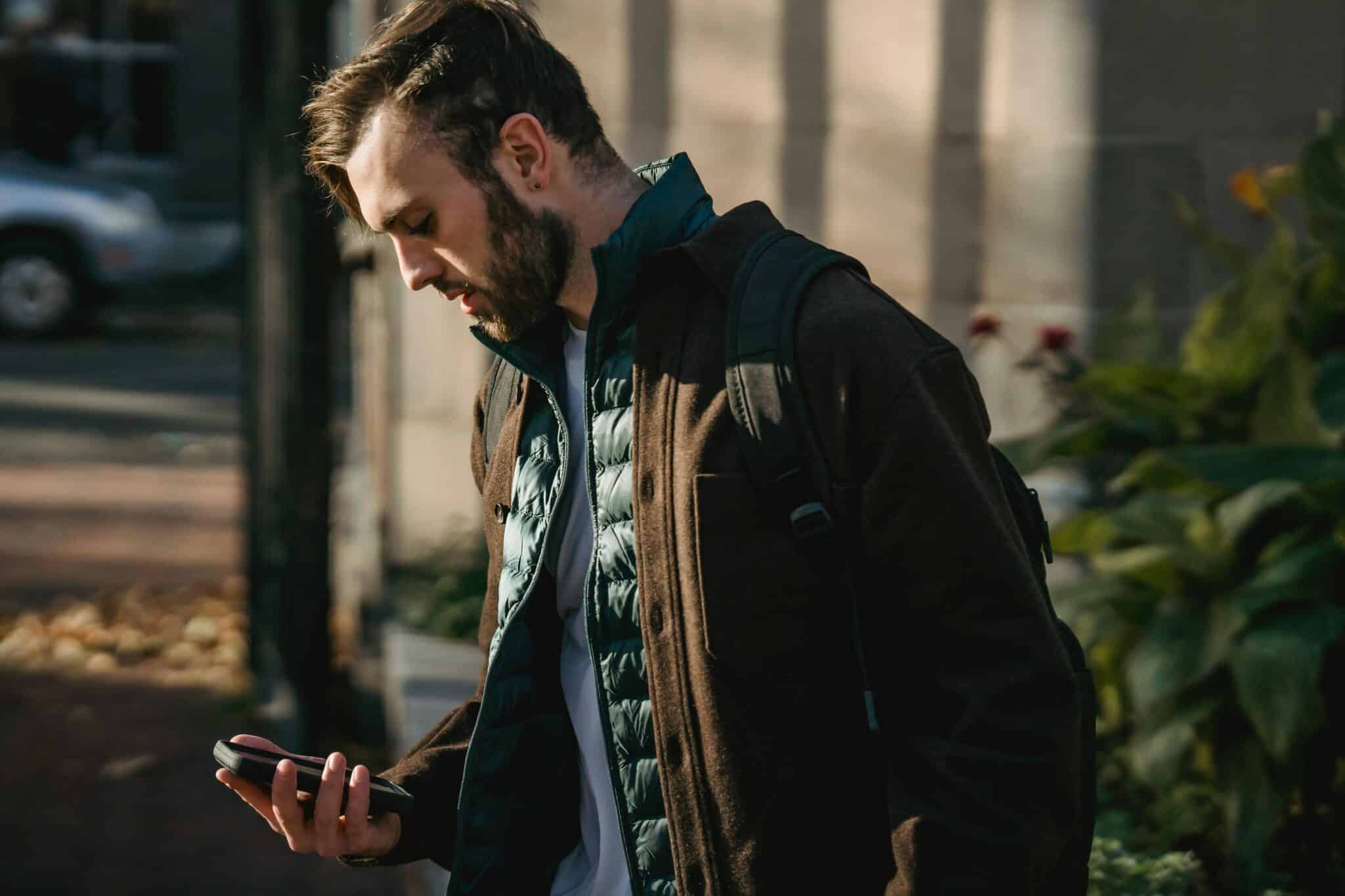 En mann som leser melding på mobilen.